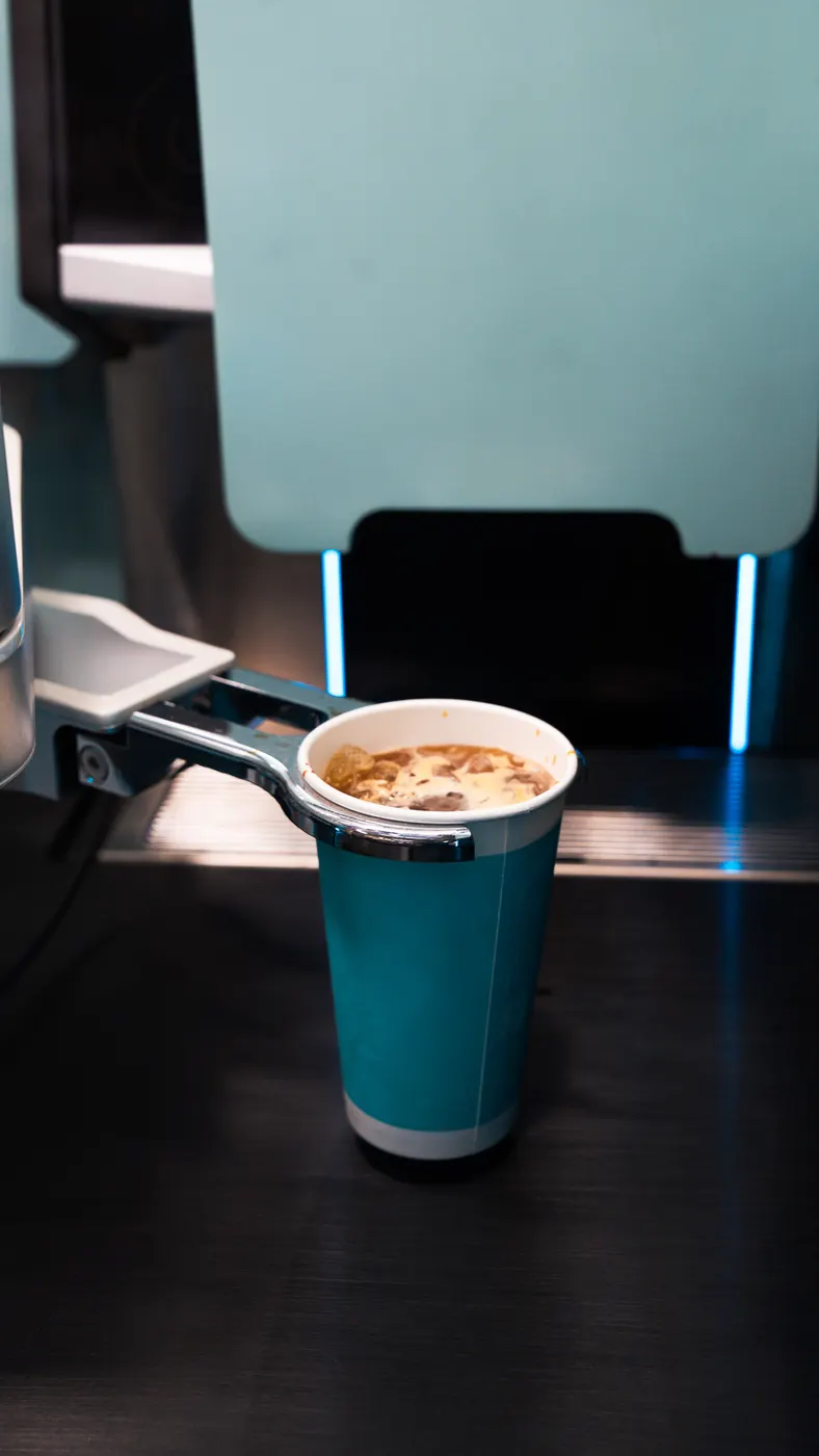 Specialty coffee fresh from the brewer, held by the STARBOT robot arm