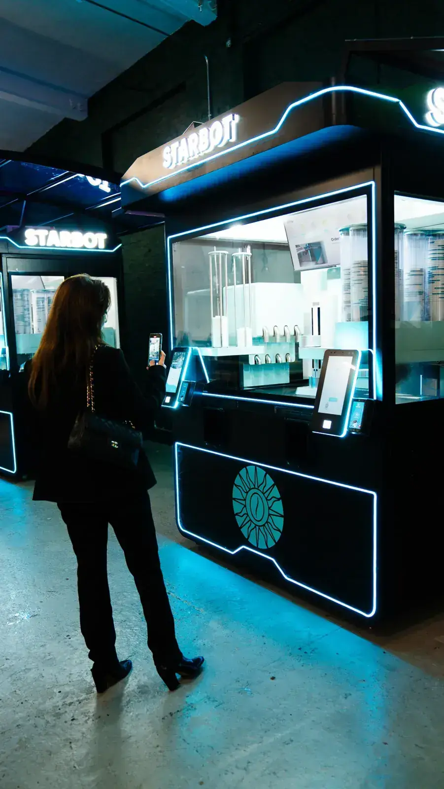 A guest collecting a coffee from the STARBOT kiosk with no staff present